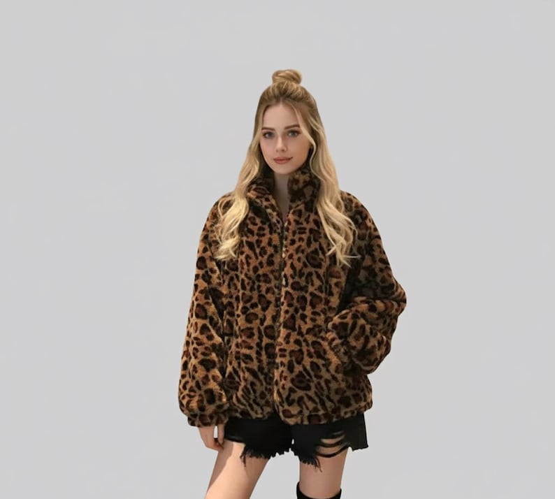 Puede incluir: Chaqueta de piel sint&eacute;tica con estampado de leopardo marr&oacute;n y negro, con cremallera y bolsillos. La chaqueta tiene cuello alto y mangas largas. La chaqueta se lleva con pantalones cortos negros.