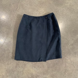 May include: A dark blue wrap skirt with a single button closure.