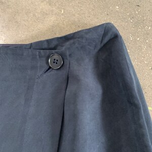 May include: A dark blue skirt with a single button closure at the waist.