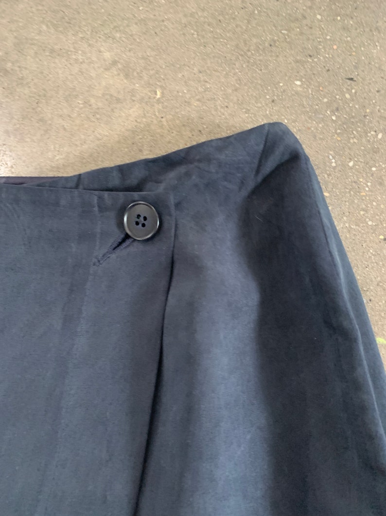 May include: A dark blue skirt with a single button closure at the waist.