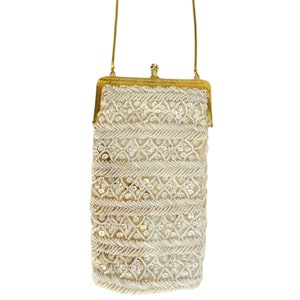 May include: A white beaded evening bag with a gold chain strap and a gold clasp.