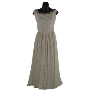 May include: A vintage ivory lace gown on a black mannequin. The sleeveless dress features a scoop neckline with delicate trim and a fitted bodice that flows into a full, floor-length skirt. The lace pattern is visible throughout the dress.