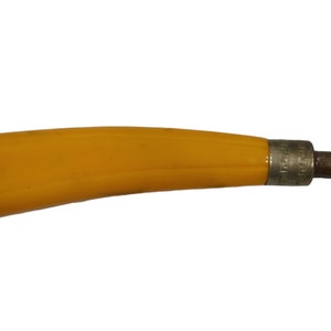 May include: A yellow plastic handle attached to a metal tool with a brown metal blade.