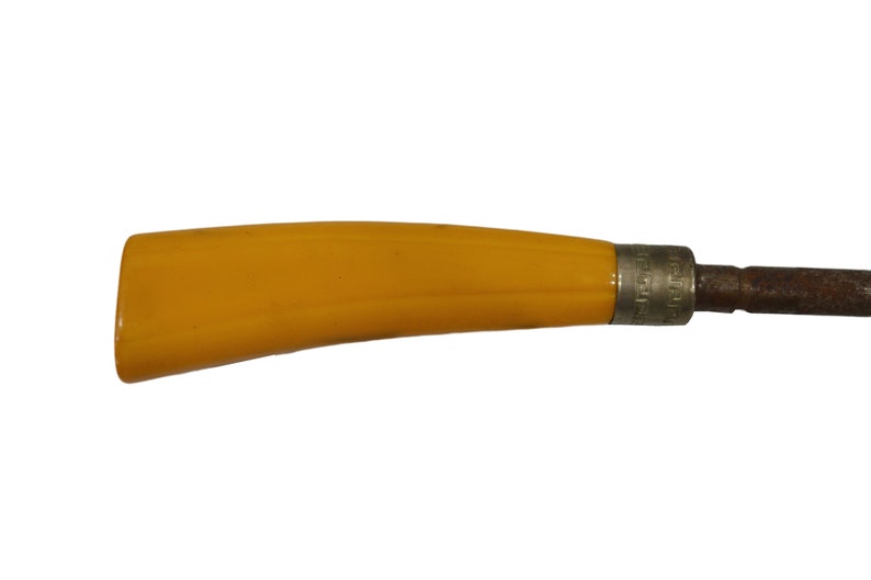 May include: A yellow plastic handle attached to a metal tool with a brown metal blade.