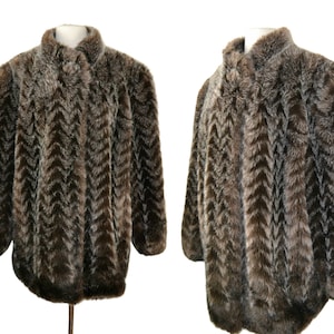 Może przedstawiać: Brązowa kurtka z imitacji futra w chevronowy wzór. Kurtka ma kołnierz i długie rękawy.