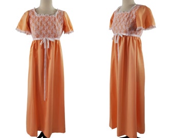 Könnte beinhalten: Ein langes, pfirsichfarbenes Kleid mit einem weißen Spitzenoberteil und einem weißen Satinband, das in der Taille gebunden ist.
