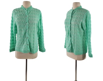 Pode incluir: Um cardigan de crochê verde menta com fecho de botões e mangas compridas.