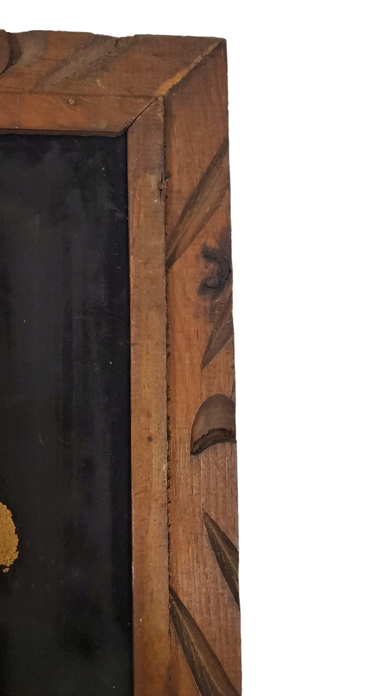 May include: A wooden frame with a carved design. The frame is dark brown and has a black background.