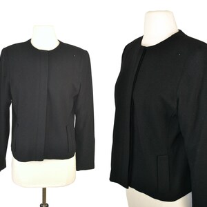 May include: A black cropped blazer with a zipper closure and long sleeves.