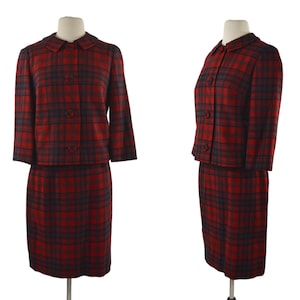 Puede incluir: Un traje de falda rojo y negro a cuadros con una chaqueta de cuello y tres botones. La falda y la chaqueta son ambas hasta la rodilla.
