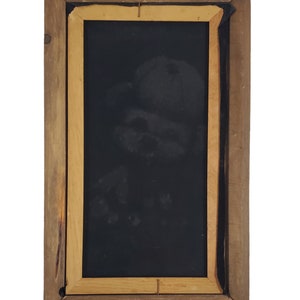 May include: A wooden picture frame with a black background. The frame is brown with a lighter wood trim.