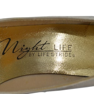 May include: Close-up of the inside of a shoe with a gold insole. The insole has the text "Night Life by Life Stride" printed on it.