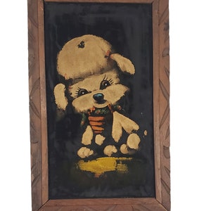 May include: A framed black velvet painting of a white poodle wearing a red bow and a green and orange scarf. The poodle is sitting on a yellow background.