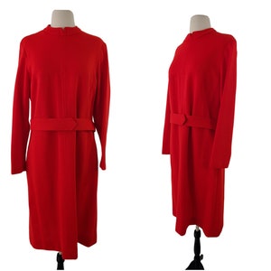 May include: A red dress with a high neckline and a belt. The dress has long sleeves and a straight silhouette.