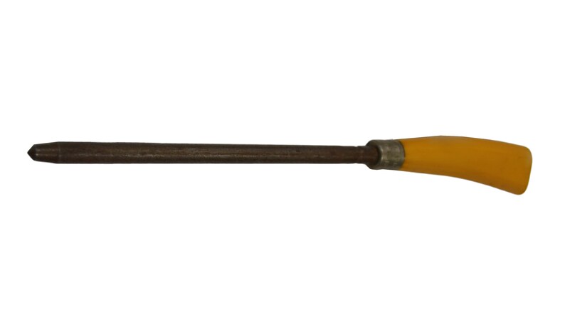 May include: A wooden tool with a yellow plastic handle. The tool has a pointed tip and a long, thin shaft.