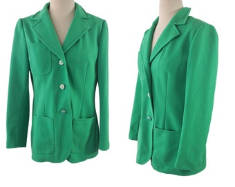 May include: A green blazer with a notched collar, two flap pockets, and three buttons. The blazer is on a white background.