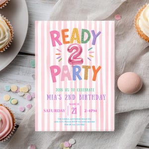 May include: A pink and white striped birthday invitation with the text "READY 2 PARTY" in colorful letters. The invitation is for Mia's 2nd birthday, with the date and time listed. Cupcakes and confetti surround the invitation.