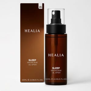 May include: A brown glass bottle of HEALIA Sleep Magnesium Oil Spray with a black spray nozzle and a matching box. The box and bottle both feature the HEALIA logo and product information. The bottle contains 120ml of product.