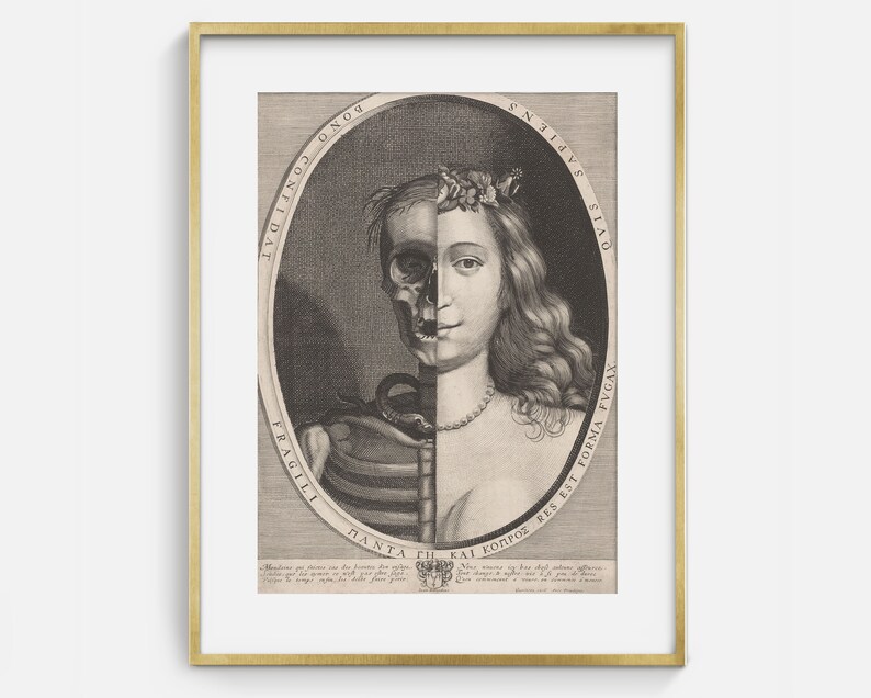 May include: An antique black and white print in a gold frame. The artwork depicts a woman's face split in half, with one side showing a skull and the other a living face. The image is surrounded by text.