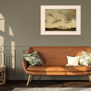 May include: A brown leather sofa with two throw pillows featuring a tropical leaf pattern. The sofa is in front of a green wall with a framed landscape painting above it.