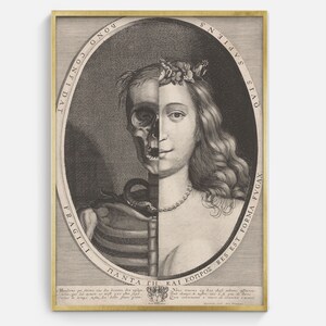 May include: A framed black and white print featuring a split portrait of a woman, one half a skull, the other a living face. The print includes Latin text and is set in a gold frame. The artwork is a vintage anatomical illustration.