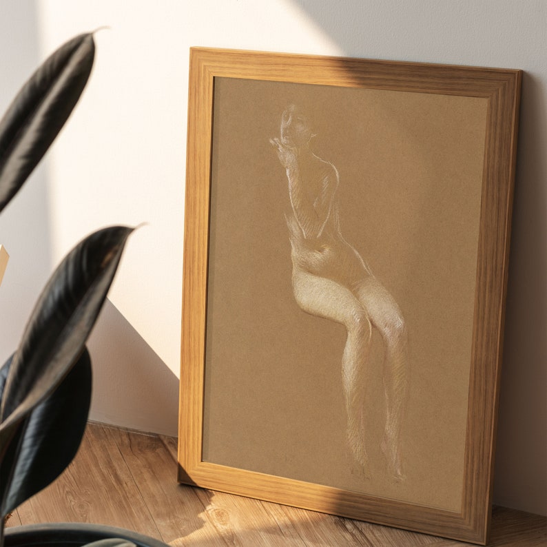 K&ouml;nnte beinhalten: Eine gerahmte Zeichnung einer nackten Figur in wei&szlig;er Kreide auf braunem Papier. Die Figur sitzt mit gekreuzten Beinen und gekreuzten Armen vor sich.