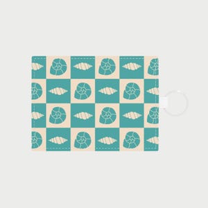 Op de afbeelding: Een rechthoekige sleutelhangerportemonnee met een herhalend patroon van turquoise en crèmekleurige schelpen op een geruite achtergrond. De portemonnee heeft een witte sleutelring aan de zijkant.