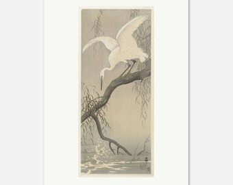 Puede incluir: Una impresión japonesa en madera representa una garceta blanca posada en una rama, con las alas extendidas. El ave está sobre el agua, con ramas de sauce. La obra de arte utiliza tonos grises y blancos. La impresión está enmarcada.