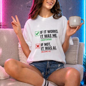 Puede incluir: Una camiseta blanca con el texto "IF IT WORKS, IT WAS ME. (SUCCESS)" y "IF NOT, IT WAS AI. (BLAME AI)". La camiseta se combina con pantalones cortos de mezclilla. Una persona sostiene una taza y hace el signo de la paz.