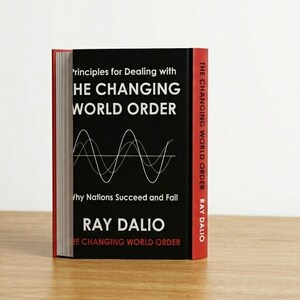 May include: A hardcover book titled Principles for Dealing with the Changing World Order: Why Nations Succeed and Fail by Ray Dalio. The black cover features white text and a white line graph illustration, with a red spine and white lettering.
