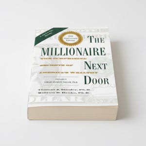 Può includere: Un libro con copertina rigida intitolato "The Millionaire Next Door" con una copertina bianca e dettagli verdi e oro. Il libro è una 20th Anniversary Edition e un bestseller del New York Times. Il titolo del libro è in grassetto.