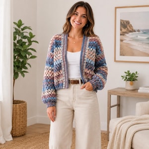 Könnte beinhalten: Ein mehrfarbiger Häkelcardigan in Blau-, Rosa- und Beigetönen. Der offene, langärmlige Pullover hat eine kastenförmige Passform. Er wird mit hellen Hosen und einem braunen Gürtel getragen. Der Cardigan ist ein stilvolles, handgefertigtes Kleidungsstück.