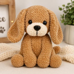 May include: A handmade plush puppy with a soft, textured, brown body, long floppy ears, and a cream-coloured muzzle. The puppy has black button eyes and a black nose. The stuffed animal is sitting upright, with its paws extended.
