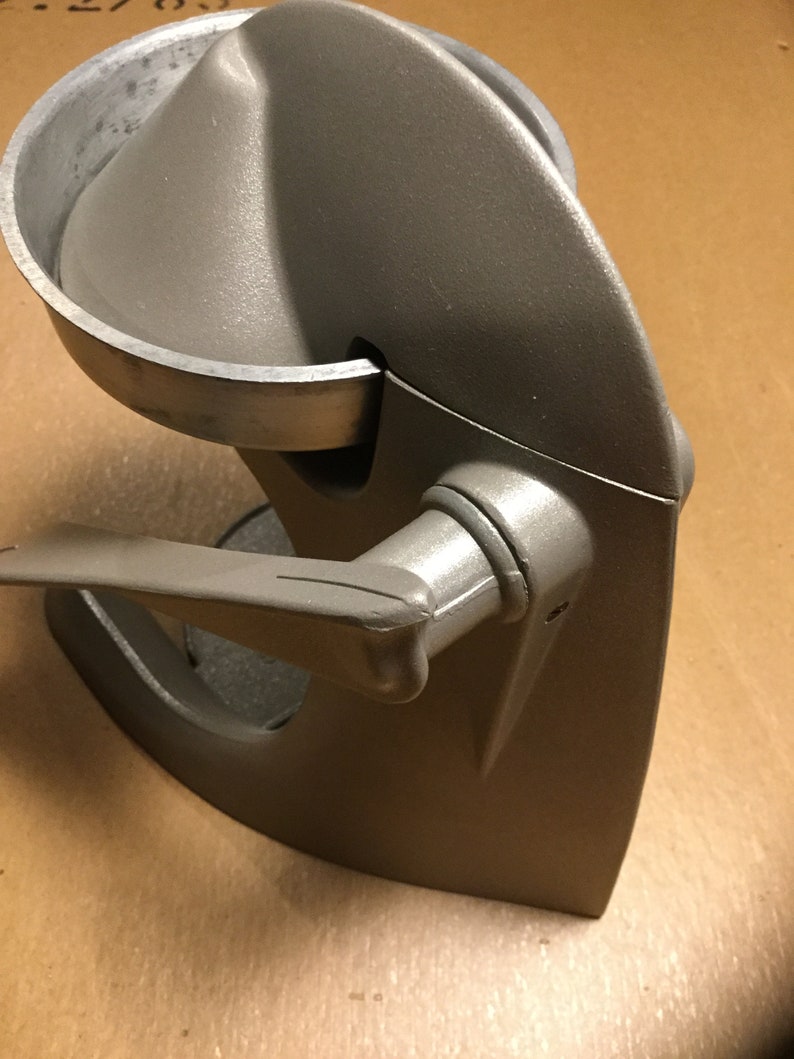 Pu&ograve; includere: Uno spremiagrumi in metallo grigio con una maniglia e una parte superiore rimovibile. Lo spremiagrumi &egrave; progettato per spremere il succo dagli agrumi.