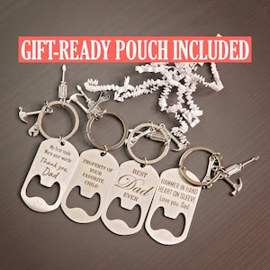 May include: A collection of silver-colored bottle opener keychains with tool-themed charms. Each keychain has a unique engraved message, including "Thank you, Dad" and "Best Dad Ever." The text "GIFT-READY POUCH INCLUDED" is displayed in a red banner.