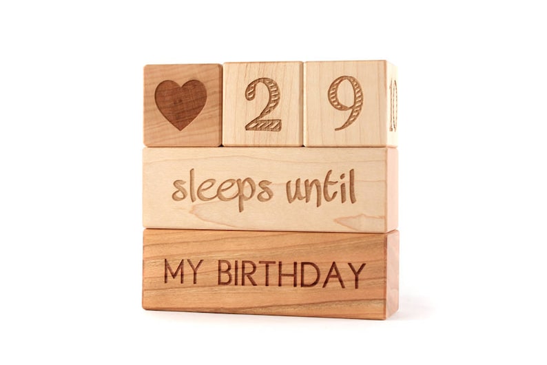 May include: Wooden blocks stacked to spell "29 sleeps until my birthday" with a heart symbol on the top block.