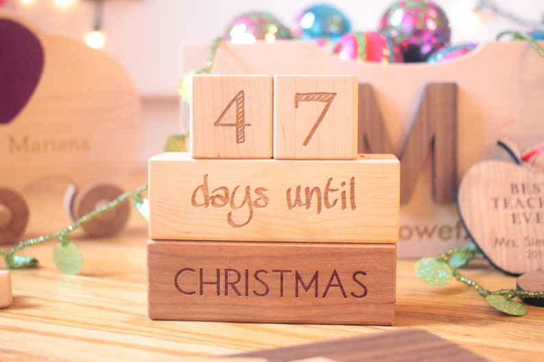 May include: Wooden block countdown calendar with the numbers 47, the words "days until Christmas", and a wooden block with the word "Christmas".