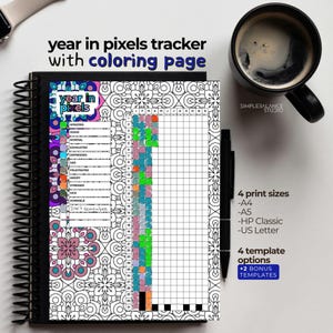 Puede incluir: Un cuaderno de espiral con un "rastreador de píxeles anual" y una página para colorear. La portada presenta un diseño floral y el texto "year in pixels tracker with coloring page." Incluye una taza de café y un bolígrafo.