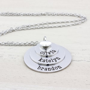 3 layer stainless steel disc necklace with kids name on each layer with a sterling silver heart charm on top.