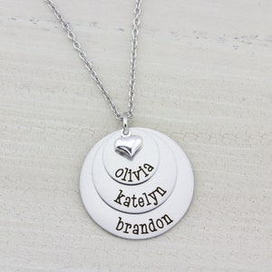 3 layer stainless steel disc necklace with kids name on each layer with a sterling silver heart charm on top.