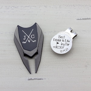 gunmetal color metal divot tool with black metal divot tool ball marker personalized with crossed clubs with initials on each side. Silver stainless steel golf marker engraved best father in law by par with golf flag graphic and date.