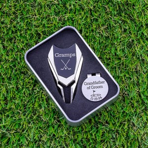 silver color metal divot tool with black metal divot tool ball marker personalized with Gramps and crossed clubs. Silver stainless steel golf marker engraved grandfather of the groom with golf flag graphic and date.