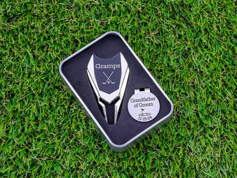 silver color metal divot tool with black metal divot tool ball marker personalized with Gramps and crossed clubs. Silver stainless steel golf marker engraved grandfather of the groom with golf flag graphic and date.