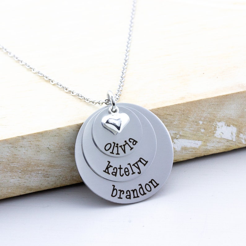 3 layer stainless steel disc necklace with kids name on each layer with a sterling silver heart charm on top.