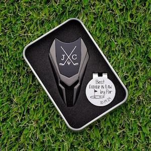 gunmetal color metal divot tool with black metal divot tool ball marker personalized with crossed clubs with initials on each side. Silver stainless steel golf marker engraved best father in law by par with golf flag graphic and date.