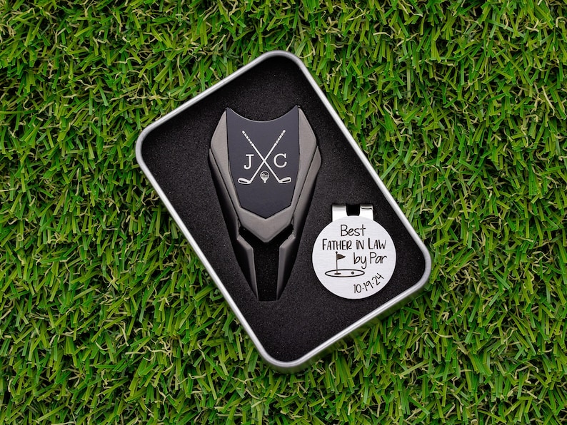 gunmetal color metal divot tool with black metal divot tool ball marker personalized with crossed clubs with initials on each side. Silver stainless steel golf marker engraved best father in law by par with golf flag graphic and date.