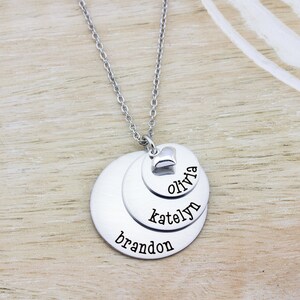 3 layer stainless steel disc necklace with kids name on each layer with a sterling silver heart charm on top.