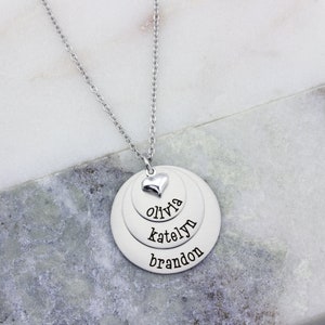3 layer stainless steel disc necklace with kids name on each layer with a sterling silver heart charm on top.