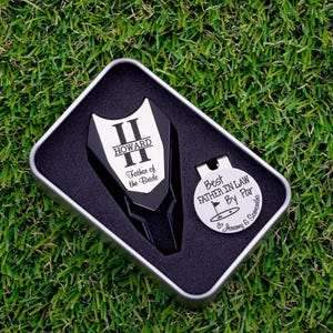 black color metal divot tool with silver metal divot tool ball marker personalized with large letter with name through it. Silver stainless steel golf marker engraved best father in law by par with golf flag graphic and names.