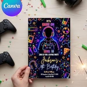 May include: A gaming-themed birthday party invitation with a neon design. The invitation features the text "It's GAME ON" and "LEVEL 10" with the name "Jackson's" and the date and time of the party. The invitation is held by a hand.